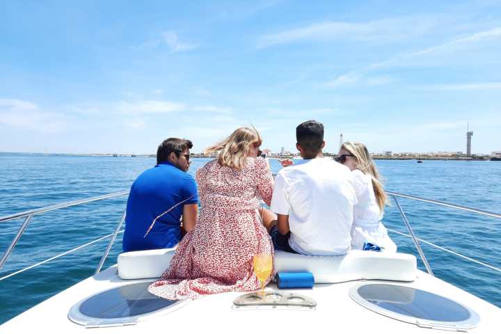 a group of people sitting in a boat on a body of water