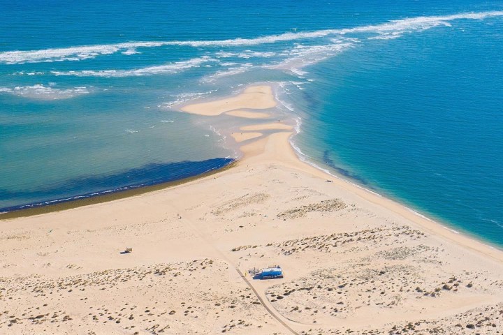 a sandy beach next to the ocean