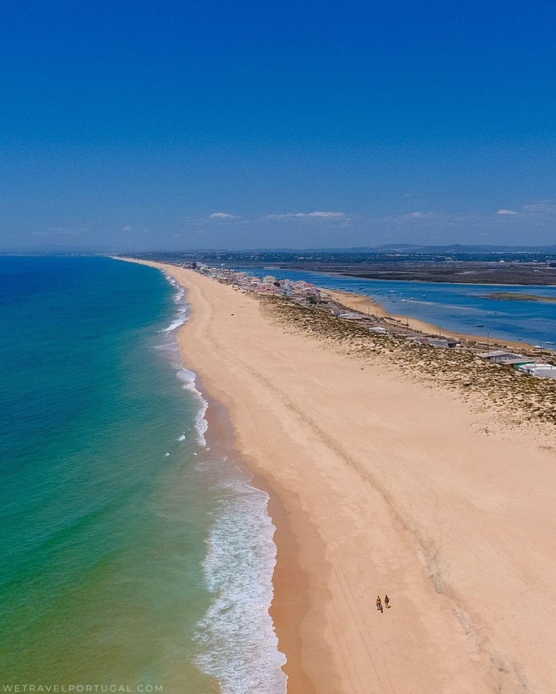 a sandy beach next to a body of water