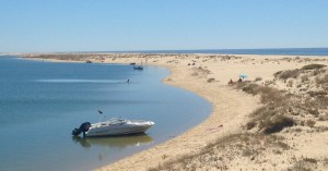a sandy beach next to a body of water