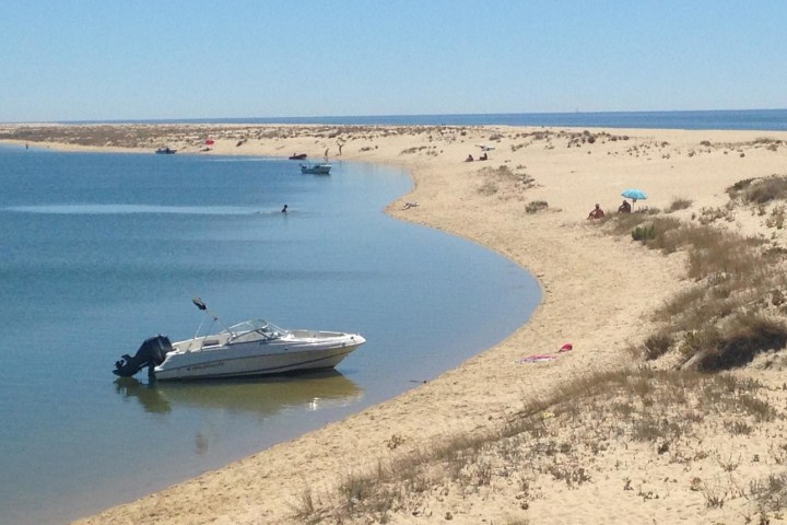 a boat sitting on top of a sandy beach
