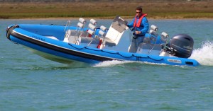 a group of people riding on the back of a boat in the water
