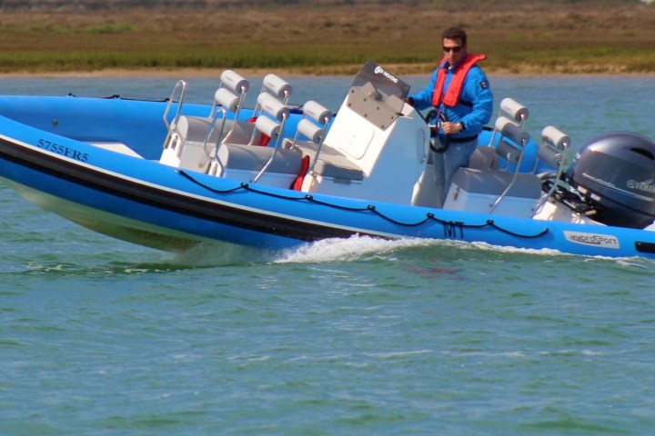 a group of people riding on the back of a boat in the water