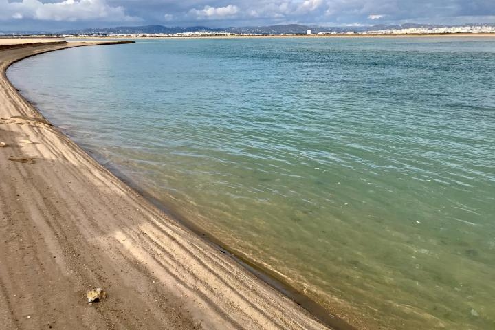 a sandy beach next to a body of water