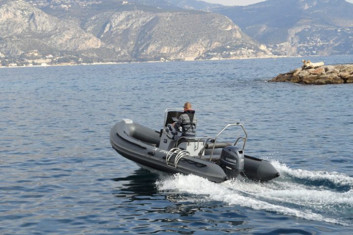 a small boat in a body of water with a mountain in the background